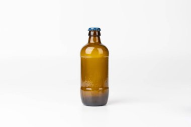 Kahverengi cam bir bira şişesinin, saf beyaz bir arkaplana karşı net ve ortalanmış bir görüntüsü ürünün parlak tasarımını minimalist bir ortamda vurguluyor.