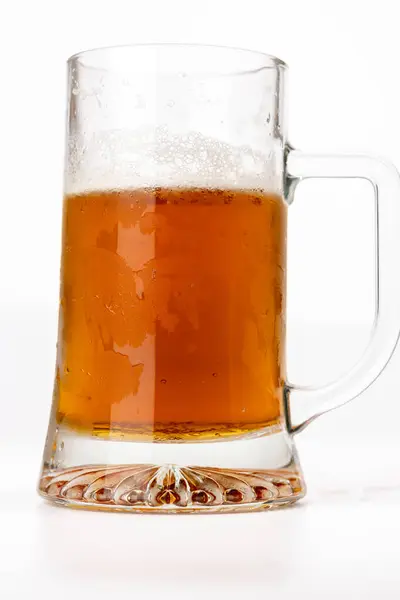 stock image Vertical photo showcasing a frosted beer mug, filled with amber-colored beer, prominently centered. The white background contrasts with the golden beer, emphasizing the refreshing look of the cold mug