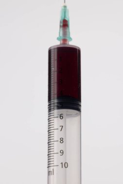 A vertical photo showcasing a detailed syringe filled with blood, centrally placed on a clean white background clipart