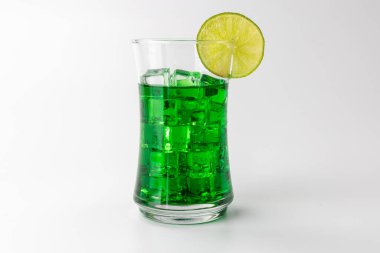 Buzlu ve limon dilimli yeşil naneli bir içeceğin ayrıntılı görüntüsü, sol tarafta temiz beyaz bir arka planda içkiyle yatay yönelimde gösteriliyor.