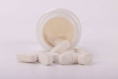 Bu ayrıntılı resimde, günlük sağlık ve tıbbi destekte ilacın önemini gösteren beyaz bir ilaç şişesi yer alıyor.