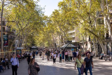 Barselona, İspanya - 15 Eylül 2024: İnsanlar Barcelonas 'ın en ikonik yerlerinden birinde sokak satıcıları ve açık hava kafelerinin önünden geçerken telaşsız bir şekilde yürüyorlar