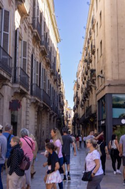 Barselona, İspanya - 15 Eylül 2024: La Rambla 'dan geçen ve Barcelonas' ın klasik şehir cazibesini ve hareketli sokak manzarasını yansıtan pitoresk bir ara sokak