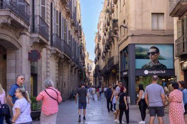 Barselona, İspanya - 15 Eylül 2024: Geleneksel Barselona mimarisi ve şehrin hareketli atmosferini vurgulayan tarihi bir ara sokak