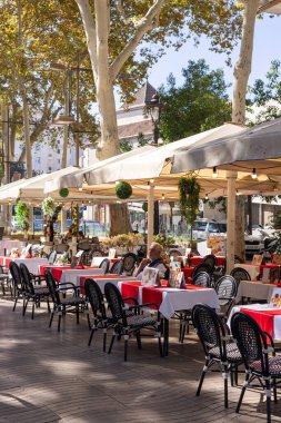 Barselona, İspanya - 15 Eylül 2024: La Rambla teraslarında yemek yiyen turistler, sağlıklı bir kahvaltı ve Barcelona 'nın ünlü caddesinin canlı atmosferinin keyfini çıkarıyorlar.