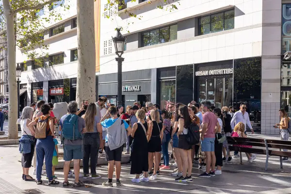 Barselona, İspanya - 15 Eylül 2024: Bir grup turist Barcelonas 'ın en ünlü meydanlarından biri olan Plaza Catalunya' nın sıcak bir günde keyfini çıkarıyorlar