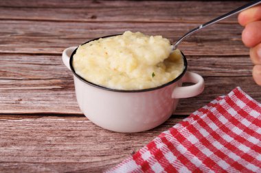 Rahatlatıcı bir kase patates püresi ve kaşıkla bir el Şükran Günü 'ndeki aile toplantılarının anılarını canlandırıyor.