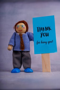 Tahta oyuncakçı elinde motivasyon mesajı gösteren mavi bir tabela tutuyor. Bu neşeli görüntü olumlu duygulara ve teşviğe ilham veriyor.