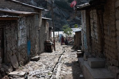 Peru - Tupe, 23 Ekim 2022: Fotoğrafta, Tupe köyünde manzaralı dağ manzarasını ve geleneksel Peru mimarisini gözler önüne seren bir sokak görülüyor.