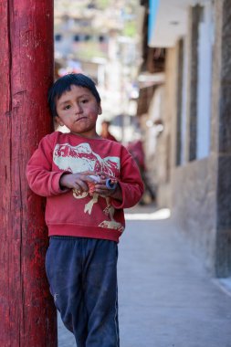 Peru - Tupe, 23 Ekim 2022: Peru dağlarında bir çocuk dönen bir top ile oynarken görüldü.