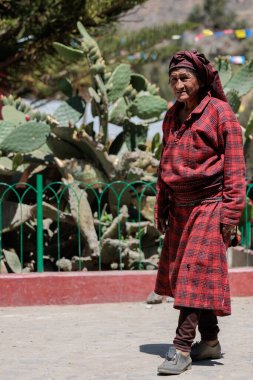 Peru - Tupe, 23 Ekim 2022: Geleneksel kıyafetler giyen yaşlı bir kadın, Peru 'nun yüksek dağlarında, Tupe sokaklarında gururla duruyor.