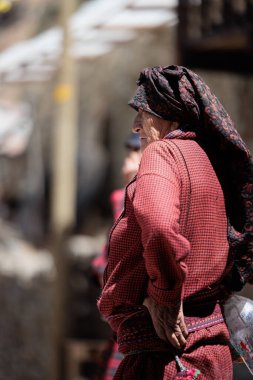 Peru - Tupe, 23 Ekim 2022: Geleneksel giysileri içinde yaşlı bir kadın görkemli dağlara karşı Tupe sokaklarında gururla duruyor