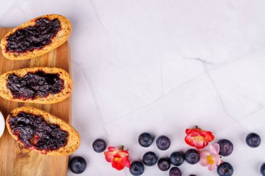 Yaban mersini reçeli ve tereyağlı, tepedeki mermer bir masanın üstüne kurulmuş kırsal kesim masası vitrinleri.