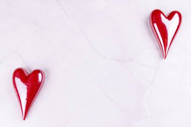 Porselenden yapılmış kırmızı ve beyaz kalpler siyah mermer bir masaya dizilir. Minimalist ama romantik bir Sevgililer Günü teması sunulur.