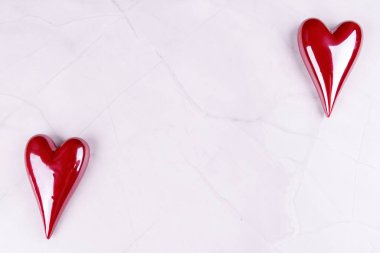 Porselenden yapılmış kırmızı ve beyaz kalpler siyah mermer bir masaya dizilir. Minimalist ama romantik bir Sevgililer Günü teması sunulur.