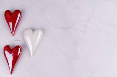 Porselenden yapılmış kırmızı ve beyaz kalpler siyah mermer bir masaya dizilir. Minimalist ama romantik bir Sevgililer Günü teması sunulur.