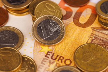 Pırıl pırıl 1 avroluk paraların el değmemiş beyaz bir zemin üzerine kurulmuş 50 avroluk banknotun üzerinde dinlendiği zarif bir hava manzarası