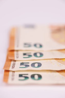 Pervane şeklinde dizilmiş 50 avroluk görsel açıdan çekici bir vuruşla, temiz beyaz bir tuvale karşı parasal değerlerini vurguluyorlar.