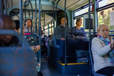 Barselona-İspanya, 28 de noviembre de 2024. Kamu otobüsünün içindeki sakin atmosferde oturanlar ve Barselona şehri manzarasını izleyenler