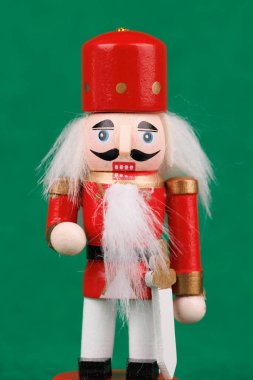 Bu tuhaf fındıkkıran, orijinal saç ve tatil unsurlarını gözler önüne seriyor, parlak yeşil bir arka planda,