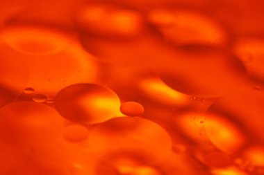 Suda yüzen yağ kabarcıkları ilginç tasarımlar yaratmak için çeşitli renklerle harmanlanmış güzel bir soyut sahne oluşturur..