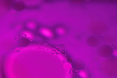 Su formunda asılı yağ kabarcıkları karmaşık ve renkli soyut desenler oluşturarak sıvı ve dinamik görsel sanatlar yaratır..