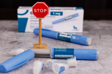 Barselona, İspanya 'da Ozempic 1 ml ve Semaglutide ilaçlarının yanında tahta dur tabelası, Sıvı Kartuş ve İğneler