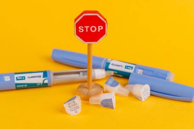 Ozempic 1 ml ve Semaglutide ilaçları ile Barselona, İspanya 'daki Parlak Sarı Arkaplan' da Tahta Durak İşaretinin Görüntüsü