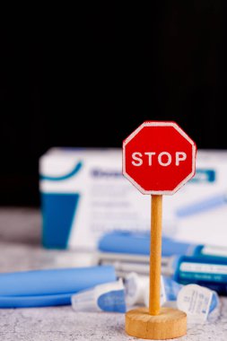 Diyabet kalemi semaglutit ile kontrol eder, çimento masa arkasındaki ahşap dur levhasının yanında sergilenir.