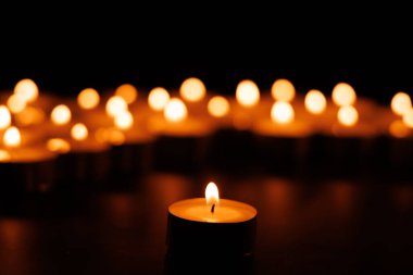 Tek bir parlayan mum sıcaklık yayar, yumuşak bulanık mumlarla çevrili, Paskalya umudunu ve duayı çağrıştıran.