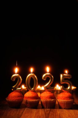 The number candles on cupcakes for 2025 shine brightly surrounded by lit candles, evoking the spirit of New Year celebrations clipart