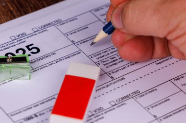 Kırmızı işaretli 15 Nisan takvimi, hesap makineleri ve kalemleri olan detaylı bir masa düzeneği, vergi sezonu hazırlığını vurguluyor