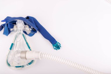 Uyku terapisi için tasarlanmış bir CPAP cihazı, beyaz bir arka planda gösterilen solunum maskesi, hava hortumu ve parlak ekran da dahil olmak üzere.