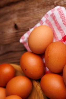 Doğal ahşap bir tabağa konmuş organik kahverengi yumurtalar, besin enflasyonunu gösteriyor..