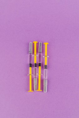 Temiz ve minimalist bir düzende, menekşe yüzeyinde şeffaf şırıngalar halinde heparin.