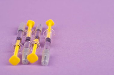 Tıbbi şırıngalar menekşe arkaplan üzerinde düzenli olarak, her biri heparin ile dolu