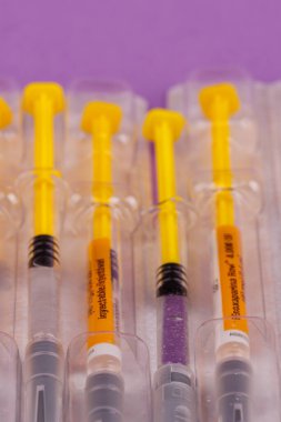 Cam şırıngaların düz yatağı ve menekşe arkaplan üzerinde heparin