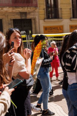 Barselona-İspanya, 23 Nisan 2025. Sant Jordi kalabalığı renkli kitap tezgahlarına göz atıyor ve La Rambla 'dan kırmızı güller alıyor..