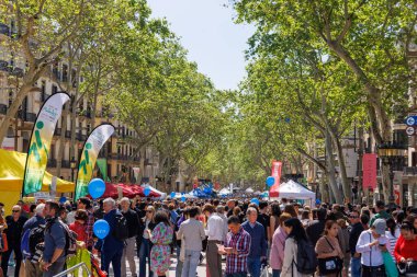 Barselona-İspanya, 23 Nisan 2025. Halk, Sant Jordi 'yi kitaplar, buğday sapları ve kırmızı güllerle onurlandırmak için toplandı..
