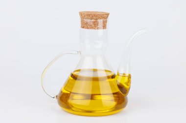 Beyaz arka planda altın zeytinyağıyla doldurulmuş cam şişe. Yemek pişirme, diyet ve Akdeniz yemek temaları için ideal.