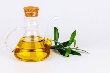 Beyaz arka planda taze zeytin dalı olan zarif zeytinyağı şişesi, Akdeniz gıda kavramları için mükemmel..
