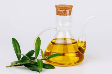 Beyaz arka planda doğal lezzeti ve organik gıdayı sembolize eden temiz yağ şişesi ve zeytin dalı.