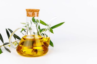 Temiz cam, altın yağ ve canlı yeşil zeytin dalından oluşan şık besin bileşimi.