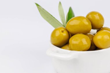 Yeşil zeytinli beyaz kâse ve beyaz, Akdeniz konseptine izole edilmiş zeytin dalı..
