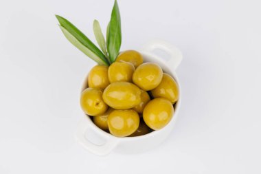 Beyaz arka planda dalları olan yeşil zeytinlerin doğal ve minimal görüntüsü, temiz ve basit.