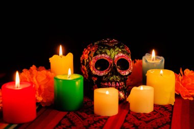 Geleneksel Meksika sunağı, siyah kafatası, manolyalar ve renkli mum ışığı ile ölüleri onurlandırıyor.