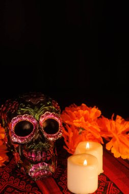 Geleneksel bir Meksika sunağında Ölüler Günü için bir çiçek kafatası, manolyalar ve parlayan mumlar bulunur..
