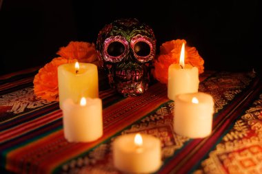 Siyah kafatası ve metal çiçeklerle dolu canlı bir sunak renkli mumlar ve manolya ölüleri onurlandırır..