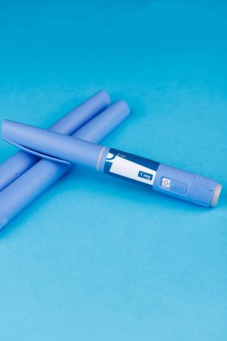 Mavi arka planda semaglutit kalemlerle kilo kaybı ve tıbbi tedavi kavramı