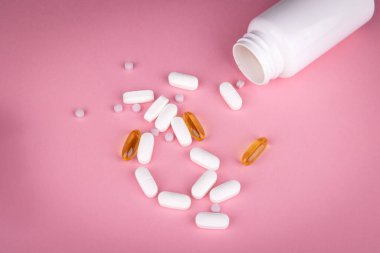 Işık saçan kalemler, beyaz hap kavanozu ve parlak pembe yüzey üzerindeki mavi mezura ile modern sağlık hizmeti görselleştirmesi